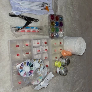 Nagelkonstset med glitter och verktyg - Ett komplett nagelkonstset med olika glitterfärger, penslar, dotting tools och tippar. Innehåller även nagelrullar och små burkar med dekoration. Inköp för ett tag sedan ifrån nagelgigabten men knappt kommit till användning☺️kommer inte gå ner i pris säljer väldigt billigt 250, köparen står för frakten