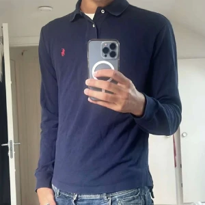 Mörkblå pikétröja från Ralph Lauren - En riktigt fet pikétröja från Ralph Lauren. Den är använd men fortfarande mycket fint skick. Kostar runt 1500 ny säljs för ett riktigt bra pris!
