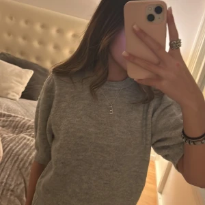 Grå tröja med puffärmar - Säljer en stilren grå tröja med puffärmar. Tröjan har en normal passform och är perfekt för både höst och vår. Den är tillverkad i ett mjukt material som ger en bekväm känsla hela dagen.