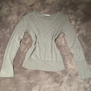 Grå v-ringad tröja, Zara - Långärmad grå v-ringad tröja från Zara. Tröjan har stretchigt material därför passar den i fler storlekar🤍💕  