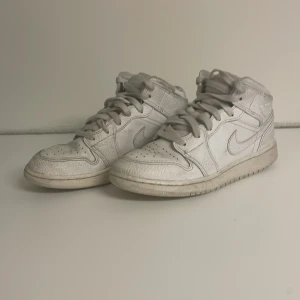 Nike Air Jordans 1 - Säljer ett par vita Nike air Jordan 1. Skorna har en högre siluett och är tillverkade i skinn. Perfekta för dig som älskar sneakers.