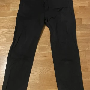 Svarta chinos - Snygga svarta chinos med en klassisk passform. Perfekta för en stilren look. De har en enkel design utan synliga detaljer.