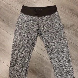Grå mönstrade leggings från SOC - Säljer ett par grå mönstrade leggings från SOC. De har en elastisk midja och är perfekta för träning. Materialet är mjukt och stretchigt för bästa komfort. Längd lite efter knä.