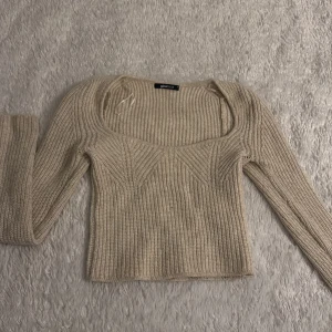 Beige ribbad stickad tröja från gina  - Säljer en stilren beige stickad tröja från Zara med ribbad struktur. Tröjan har en fyrkantig halsringning och långa ärmar, perfekt för kyligare dagar. Passar bra till både jeans och kjol. Hör av dig vid intresse!