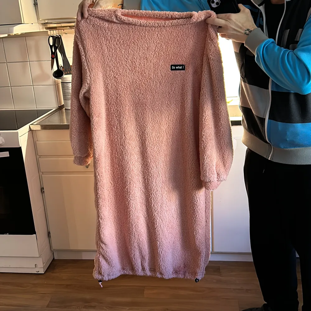 Säljer en supermysig rosa klänning från So What! i fluffigt material. Klänningen har långa ärmar och en avslappnad passform med justerbar nederkant. Perfekt för att mysa hemma eller en chill dag ute. 💖. Mekot.