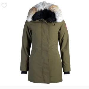Victoria parka med päls från Canada Goose - Säljer en snygg brun parkajacka från Canada Goose i mycket bra skick. Jackan har en mysig pälsfodrad huva och stängs med både dragkedja och knappar. 