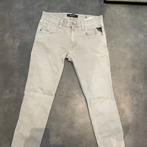 Replay anbass  - Snygga grå jeans från Replay i modellen Anbass. De har en klassisk femficksdesign med dragkedja och knapp. Perfekta för en stilren look. 30/32