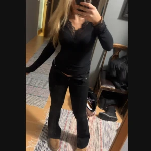 Svarta bootcut byxor - Snygga svarta bootcut byxor med låg midja och dragkedja. Perfekta för en stilren look. Passar bra till både vardag och fest.