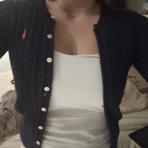 Kofta - Navyblå stickad kofta från Ralph Lauren med rosa Ralph Lauren märke. Strl 12-14 yr men sitter som s. 