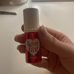 Benefit - lovetint - Säljer en röd Love Tint från Benefit som kan användas både på läppar och kinder. Den har en intensiv färg som kan blandas ut för en mjukare look. Kommer i en söt liten flaska med en applikator för enkel applicering. Säljer pga att den aldrig kom till användning, jag köpte den nypris för 329kr ❤️. Jag använde den bara nu för att visa hur den såg ut på.