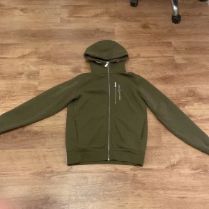 Sail Racing Hoodie - Säljer en grön sail racing hoodie har knaps använd som ny. Om man ska köpa den ny kostar det 1500 ungefär. Väldigt varm och bra för vinter.
