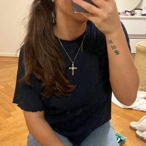 Mörkblå ribbad topp - Säljer en stilren mörkblå ribbad topp med korta ärmar. Perfekt för en avslappnad look. Toppen har en enkel design som gör den lätt att matcha med olika outfits.