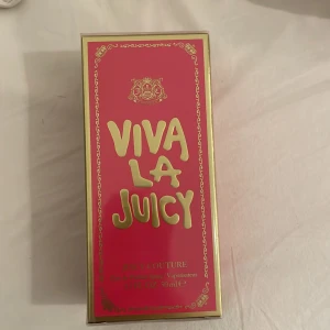 Viva La Juicy Parfym från Juicy Couture - Säljer en Viva La Juicy parfym från Juicy Couture. Förpackningen är i en livlig rosa färg med gyllene detaljer och text. Flaskan innehåller 50 ml av denna populära doft.