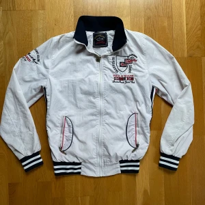 Windbreaker från Paul & Shark - Säljer en riktigt nice vit windbreaker från Paul & Shark med broderade detaljer och dragkedja. Jackan har ribbade muddar och krage i marinblått och vitt. Perfekt för en stilren look med en touch av yachting-vibe samt en perfekt jacka till våren och sena sommardagar!Str: S Skick: 8,5/10. Går självklart att diskutera priset och de är bara att fråga om mer information!