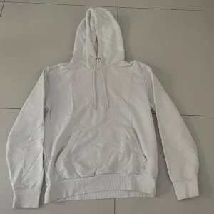 Vit hoodie från Calvin Klein  - Säljer en stilren vit hoodie från Calvin Klein i bra skick. Den har en klassisk design med en stor ficka fram och justerbar huva med snören. Perfekt för en avslappnad look eller kyliga dagar. Passar till det mesta och är superbekväm!