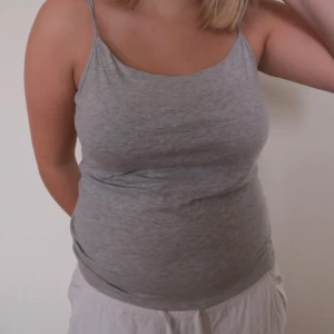 Grå linnetopp från Basic you - Säljer en enkel och stilren grå linnetopp från Basic you. Perfekt för sommardagar eller som ett basplagg i garderoben. Toppen har smala axelband och är i ett mjukt bomullsmaterial. Passar till både jeans och kjol!