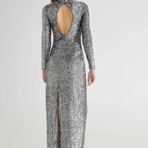 Silver paljettklänning från Limited Collection Gina tonic  - Säljer en glittrig silverfärgad paljettklänning från Limited Collection Gina. Klänningen har långa ärmar och en djup öppen rygg, perfekt för festliga tillfällen. Den är i storlek S och passar även XS-M. Perfekt för nyår eller andra glamorösa fester! ✨