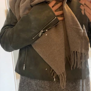 Halsduk Tiger Of Sweden - Den har små bitar där tyget är lite tunnare, det syns när man håller upp den mot ljuset men inte när man har den på sig. Bör framgå på bilderna :) Beige med grå ton.