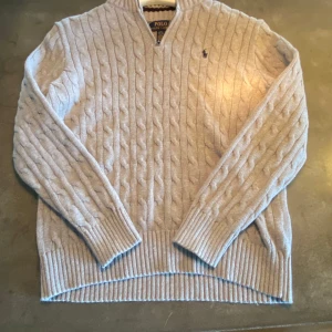 Grå Ralph lauren kabelstickad half zip - Riktigt schysst half zip. bra kvalitet. Den är knappt andvänd, max 2-3 ggr. Storleken är xs men passar upp till S.