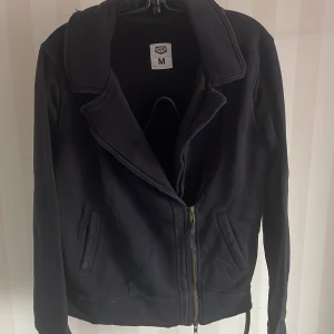 Svart jacka från Crocker - Säljer en svart jacka från Crocker i storlek M. Den har en dragkedja framtill och långa ärmar. Perfekt för höst och vår. Jackan är i bra skick och redo för nya äventyr!