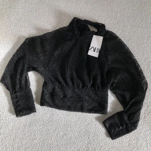 ZARA svart spetsblus - Otroligt snygg och elegant blus från ZARA med vacker spets och knappar längs med ärmslut. Öppen rygg och knyts med rosett i nacken. Ny mer prislappar, utan anmärkningar. 
