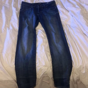 Mörkblå jeans från Jack & Jones - Säljer ett par snygga mörkblå jeans från Jack & Jones i storlek 29/32. De har en klassisk femficksdesign och en bekväm passform. Perfekta för både vardag och fest! 🕺