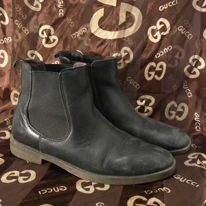 Svarta Chelsea boots från Tamaris - Säljer ett par svarta Chelsea boots från Tamaris i skinn. De är i välanvänt skick men fortfarande snygga och bekväma. Perfekta för höst och vår med en klassisk stil som passar till det mesta. Storlek 37.