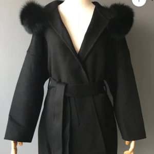 Svart vinterkappa i äkta rävpäls  - Svart vinterkappa i äkta rävpäls. Endast använd fåtal gånger. I mycket gott skick! Köpt i storlek XS men motsvarar S då den är oversize. Köpt från Fur Stockholm för 2200 kr. 