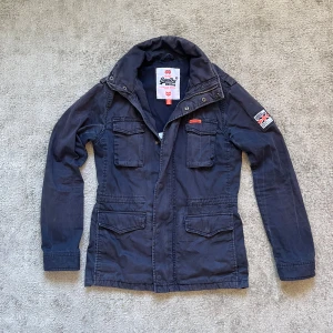 Field jacket - Säljer en field jacket från Superdry. Den är använd men i bra skick! Storlek S. Hör av dig vid fler frågor!