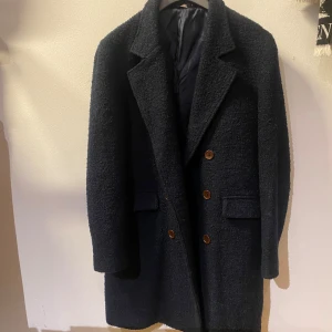Svart/blå Gant kappa i ull - Medellång kappa i mörkblå/svart färg från GANT, går till strax under knäna och är i jättmysigt material 🐑  Nypris 4500