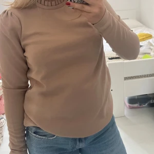 Beige/brun tröja  - Beige/brun tröja från aware med ”volanger” vid kragen samt markering vid axlarna
