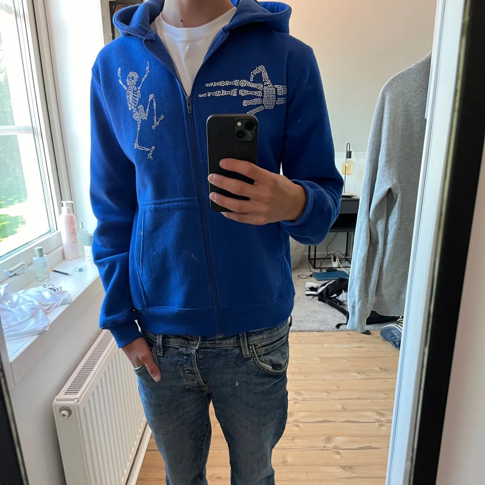 Säljer en snygg blå hoodie| mönstrens är gjorda i rhinestone| är i storlek s| använd 4 gånger så skicket är 9/10| Perfekt för en avslappnad stil och passar bra till jeans. Den är i bra skick och redo för nya äventyr!. Tröjor & Koftor.