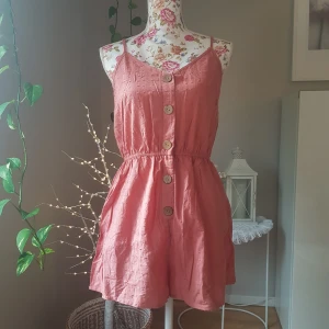 NY romper, med resår och knappar - Ny i påse, från Shein. Passar stl S/M. Bomullstyg i korallfärg, fejk-knäppning. ~ STOR rensning & klänningsbonanza i min shop ~ Välj 5 för 100kr oavsett pris, skicka medd/lämna som prisförslag (gäller där det står) ~