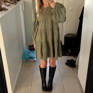 Olivgrön klänning från Gina Tricot - Säljer en superfin olivgrön klänning från Gina Tricot i storlek 36. Den har en lös passform med långa ärmar och en söt knytning i ryggen. 💚