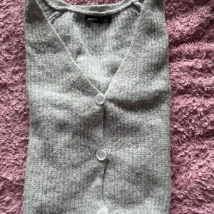 Grå stickad kofta från Shein - Mysig grå stickad kofta från Shein med v-ringning och knappar framtill. Perfekt för kyliga dagar när du vill vara både bekväm och stilren. Passar till både vardag och lite finare tillfällen.