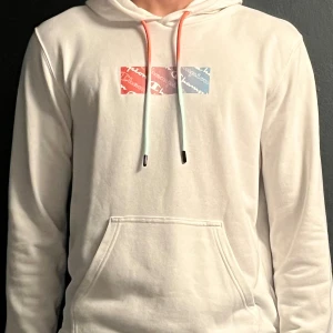 Hoodie (vit) - En vit hoodie från Champion med tryck på bröstet. Den har storleken M och är en lite tunnare hoodie. Väldigt bra skick.