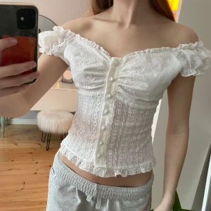 Vit offshoulder blus med spetsdetaljer - Säljer en vit offshoulder blus med spetsdetaljer och knappar framtill. Perfekt till sommaren 🌸