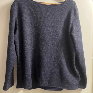 Mörkblå stickad tröja - Säljer en stilren mörkblå stickad tröja med långa ärmar. Perfekt för kyligare dagar och enkel att matcha med olika outfits.