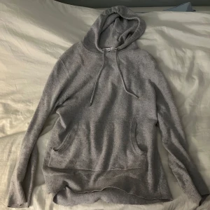 Kashmir hoodie - Säljer en Kashmir och bomull grå hoodie med justerbar huva och ficka framtill. Perfekt för en avslappnad look. Tröjan är lite nopprig men annars i bra skick. Står M men passar XS/S