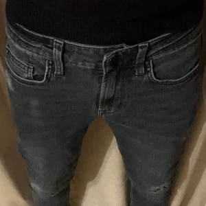 Mörkblå jeans - Snygga mörkblå jeans med en klassisk femficksdesign. De har en smal passform och är perfekta för en stilren look. Jeansen har en knappgylf och bälteshällor för extra stil och funktionalitet.