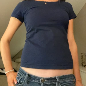 Mörkblå t-shirt från Kappa - Säljer en mörkblå t-shirt från Kappa med korta ärmar. Perfekt för en avslappnad stil. T-shirten har en liten logga på bröstet och är gjord i ett mjukt material.