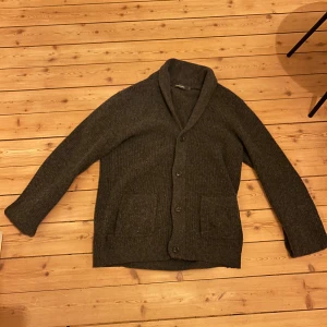 Grå kofta från Dressmann - Säljer en grå kofta från Dressmann i storlek M. Koftan har långa ärmar och knappar framtill. Perfekt för kyligare dagar med sina praktiska fickor och mjuka material. 