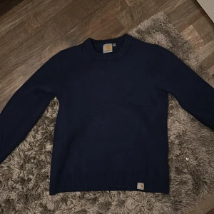 Mörkblå stickad tröja från Carhartt - fråga om ni undrar något! Säljer en stilren mörkblå stickad tröja från Carhartt. Tröjan har en klassisk rund halsringning och ribbade muddar vid ärmslut och nederkant. Den är i storlek large men passar extra small, den är väldigt liten.  Pris kan diskuteras