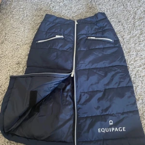 Mörkblå vadderad kjol från Equipage - Snygg mörkblå vadderad kjol från Equipage med dragkedja framtill och praktiska fickor med dragkedja. Perfekt för kyligare dagar med sin quiltade design och elastiska midja för extra komfort.