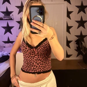 Leopardmönstrad linne med spetsdetaljer - Trendig leopardmönstrad linne i rosa och svart med spetsdetaljer vid halsringningen och nederkanten. 