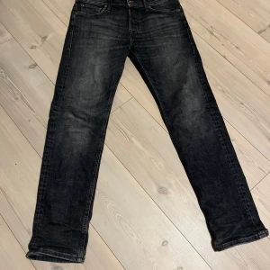 Svarta jeans från Jack & Jones - Snygga svarta jeans från Jack & Jones med en tapered passform. De har en klassisk design med fem fickor och knappgylf. Perfekta för en stilren look. De är i bra skick skriv vid funderingar 