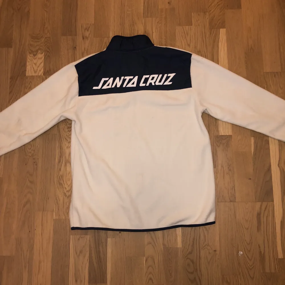 Snygg vit med blå detaljer fleece tröja med storlek M, kan passa för smaller fit L. Har en ytterst liten fläck som inte syns när man har på den.. Neuletakit & Villapaidat.