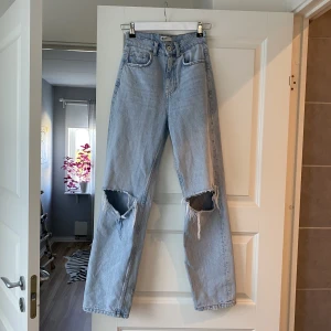 Jeans med hål - Säljer ett par ljusblåa jeans från gina tricot i modellen 90s high waist jeans. Bra skick förutom en liten fläck på benet som syns på tredje bilden. Man kan även köpa med andra saker från min profil, allt ska bort😊