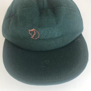 Fjällräven  - Keps med öronlappsfåtölj, fodrad. Väldigt fint skick