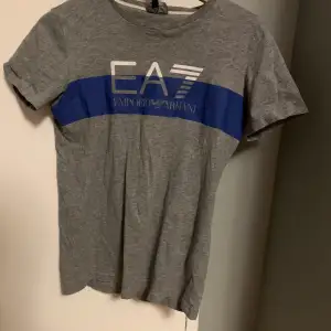 Säljer äkta EA7 t-shirt. Tröjan är köpt från JD sports. Storleken på tröjan är 166 cm, skulle säga att den sitter som en XS. 